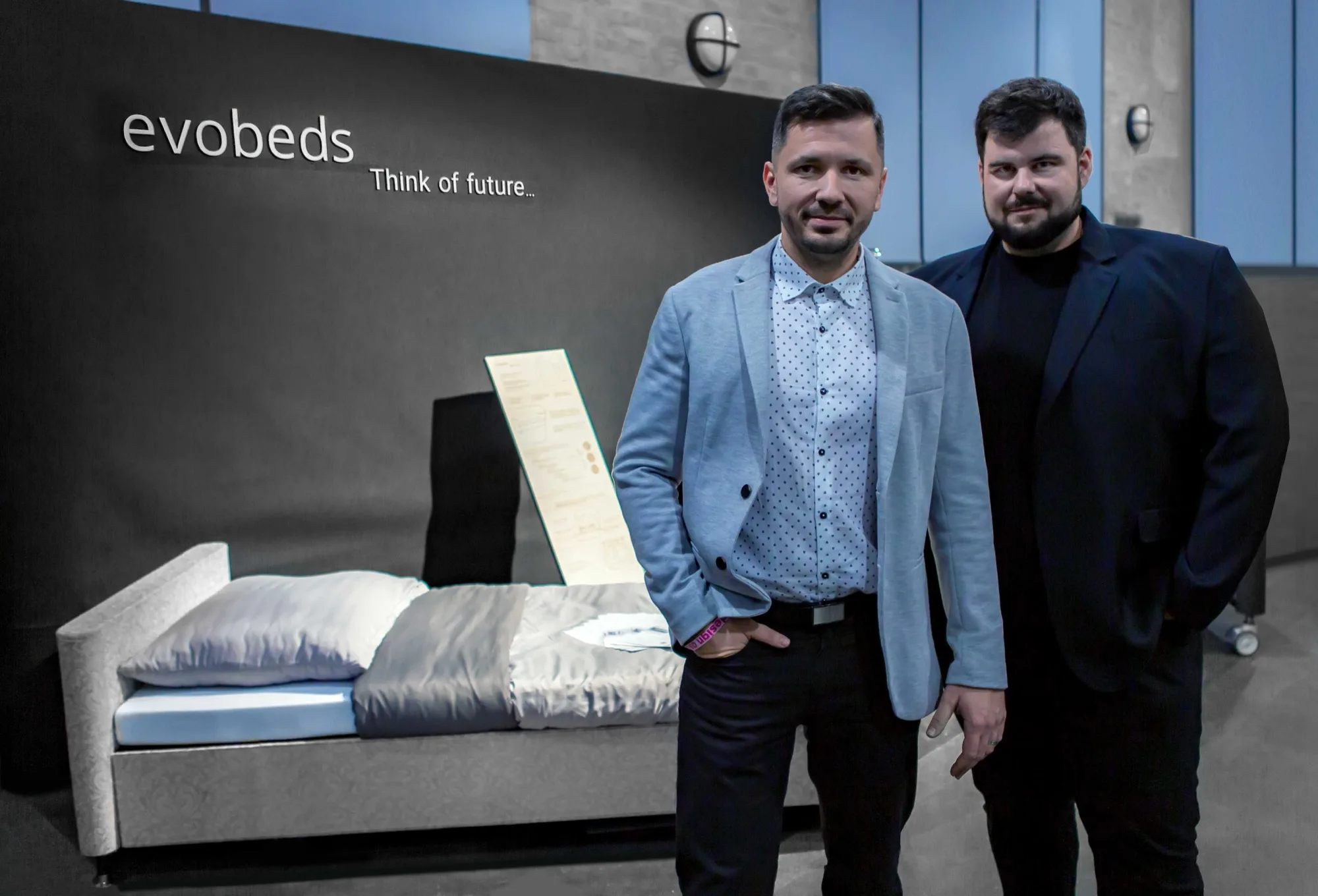 Zakladatelé evobeds u postele na výstavě, v pozadí nápis evobeds Think of future
